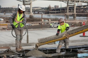 Workers pour concrete on the western approach to the new bridge for the Portland-Milwaukie Light Rail Transit Project.