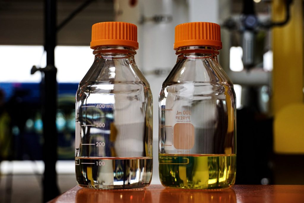 Two containers of diesel with orange caps, the one on the left is renewable diesel.