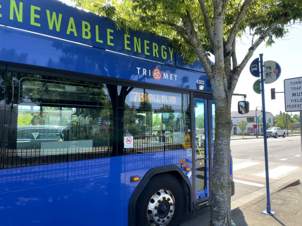 A zero-emissions bus on Line 76-Hall/Greenburg serves the bus stop at the Tualatin WES Station.