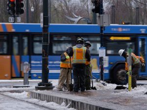 Image of workers with snow shovels on a street corner.