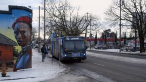 Image of a TriMet bus driving along a plowed street in Portland.