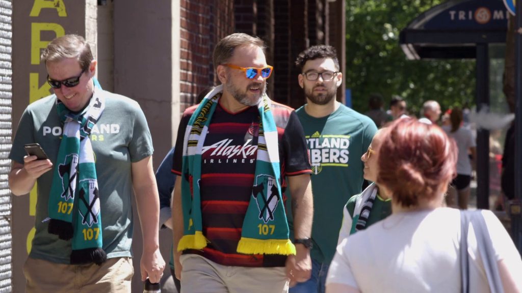 Image of Portland Timbers fans leaving a TriMet bus stop.