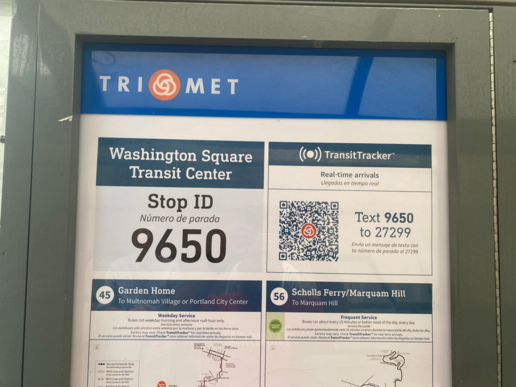 Image of a TriMet poster at the Washington Square Transit Center with a TransitTracker QR code next to the message "Text 9650 to 27299."